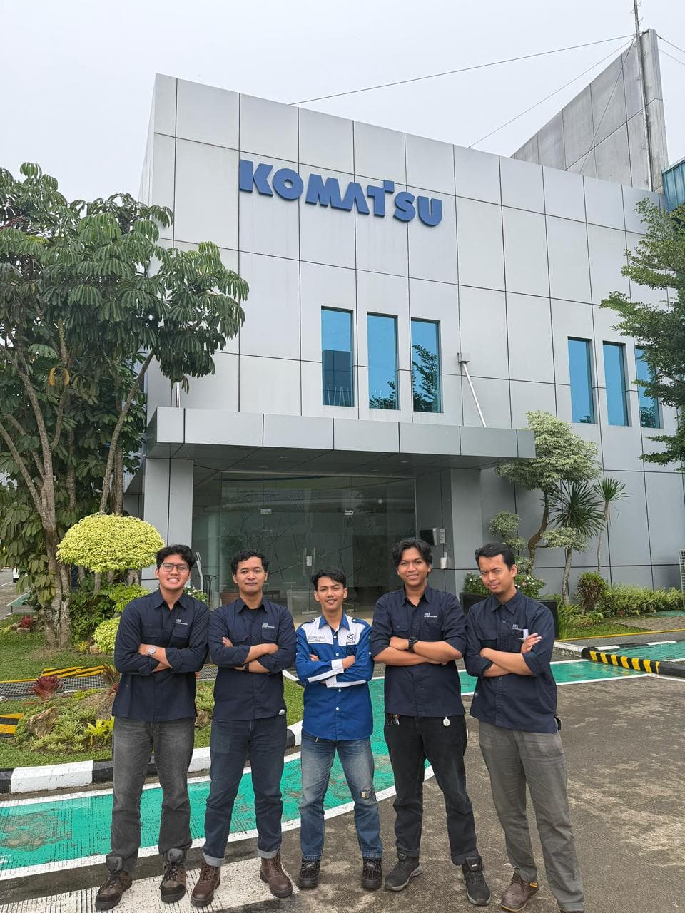 Iqmal with the Komatsu Remanufacturing Asia development team outside the company office