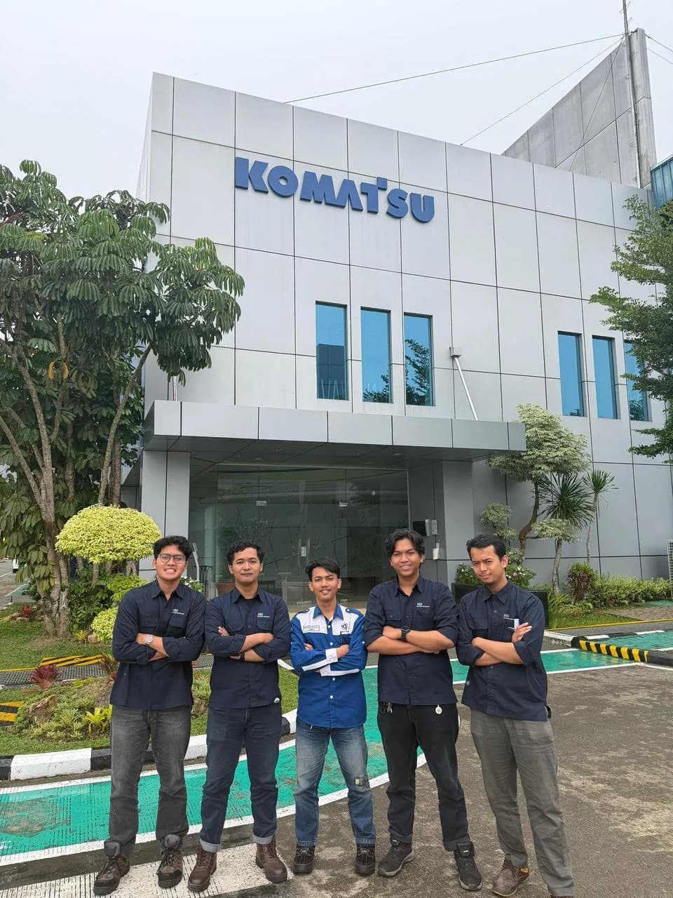 Iqmal with the Komatsu Remanufacturing Asia development team outside the company office